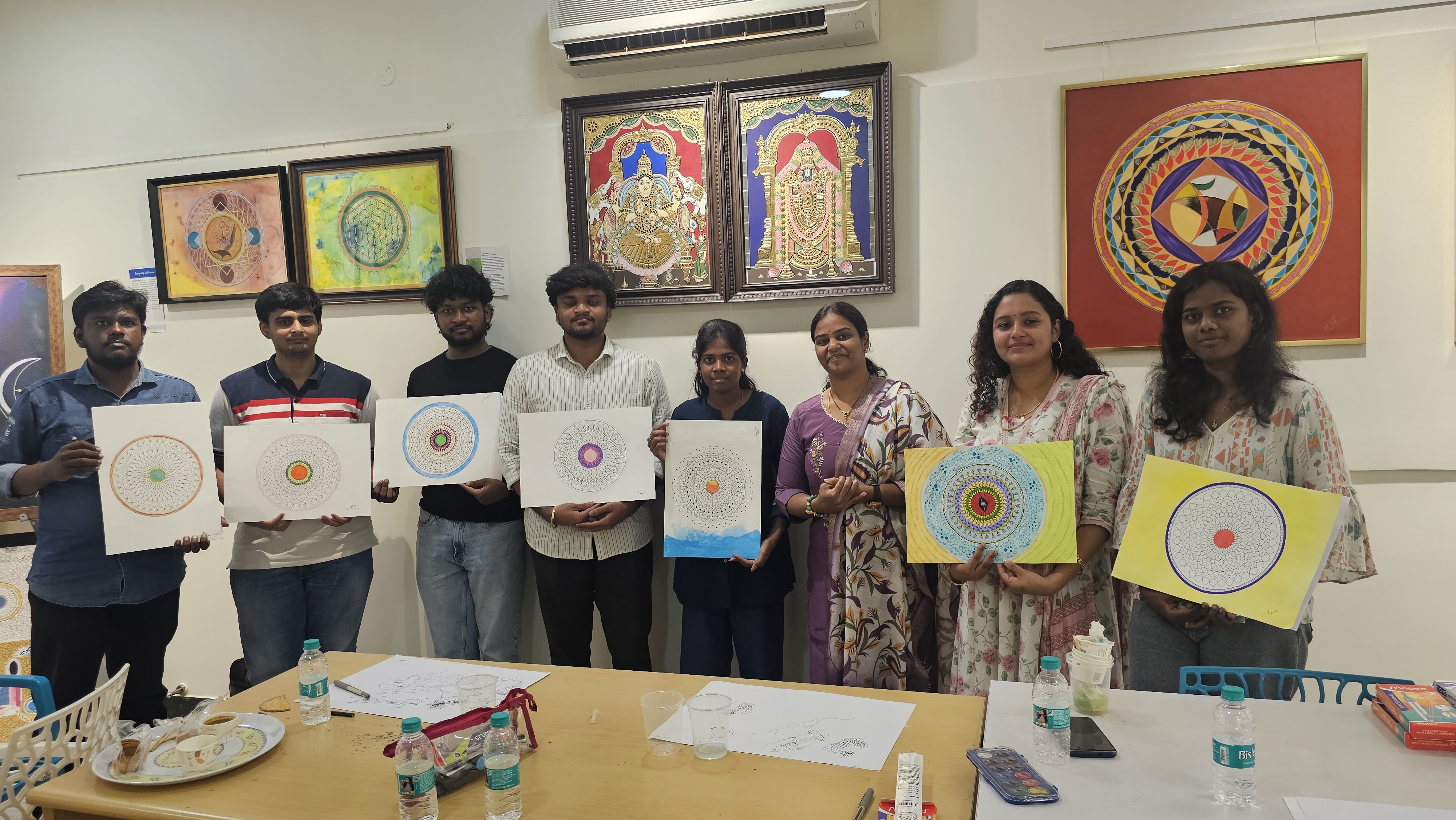 Students proudly holding their completed mandalas after a Varaaz Arts workshop